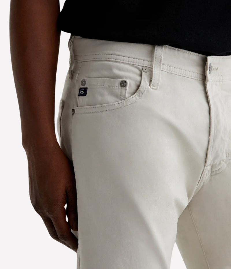 Men’s slim-fit five-pocket pants in an ultra-pale grey, crafted from soft and lightweight Italian Sueded Stretch Sateen. Features a mid-rise waist, fitted upper block, and tapered leg for a modern, polished look.