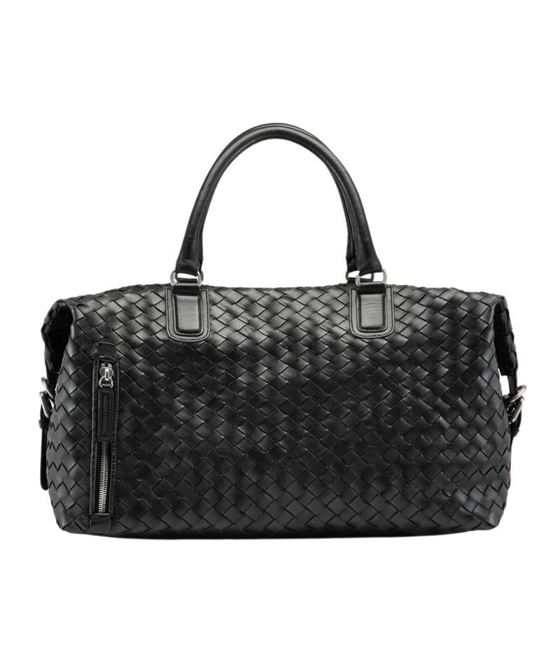 Handwoven black leather Armor 019 Travel Bag with durable handles, an adjustable shoulder strap, side buckles, and a spacious interior with a side zipper pocket. Made in Italy.