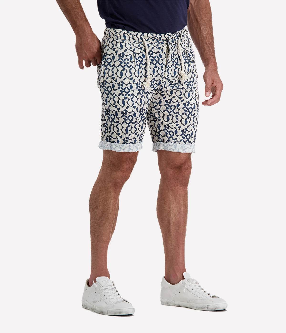 Navy and white patterned linen shorts with a rope drawstring and button closure, styled with a slight roll for a relaxed, effortless look. Breathable and lightweight, perfect for beach days or casual nights out.