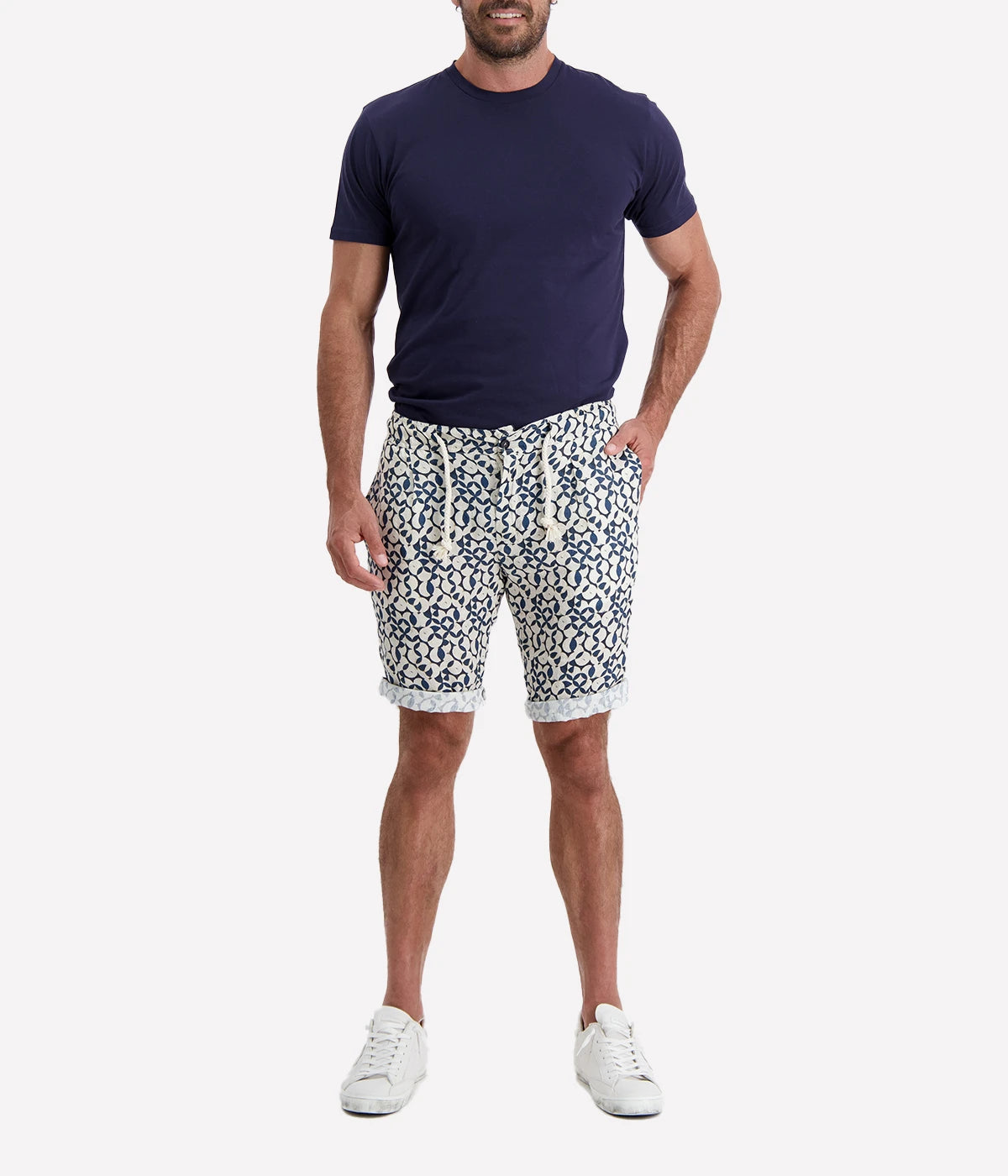 Navy and white patterned linen shorts with a rope drawstring and button closure, styled with a slight roll for a relaxed, effortless look. Breathable and lightweight, perfect for beach days or casual nights out.