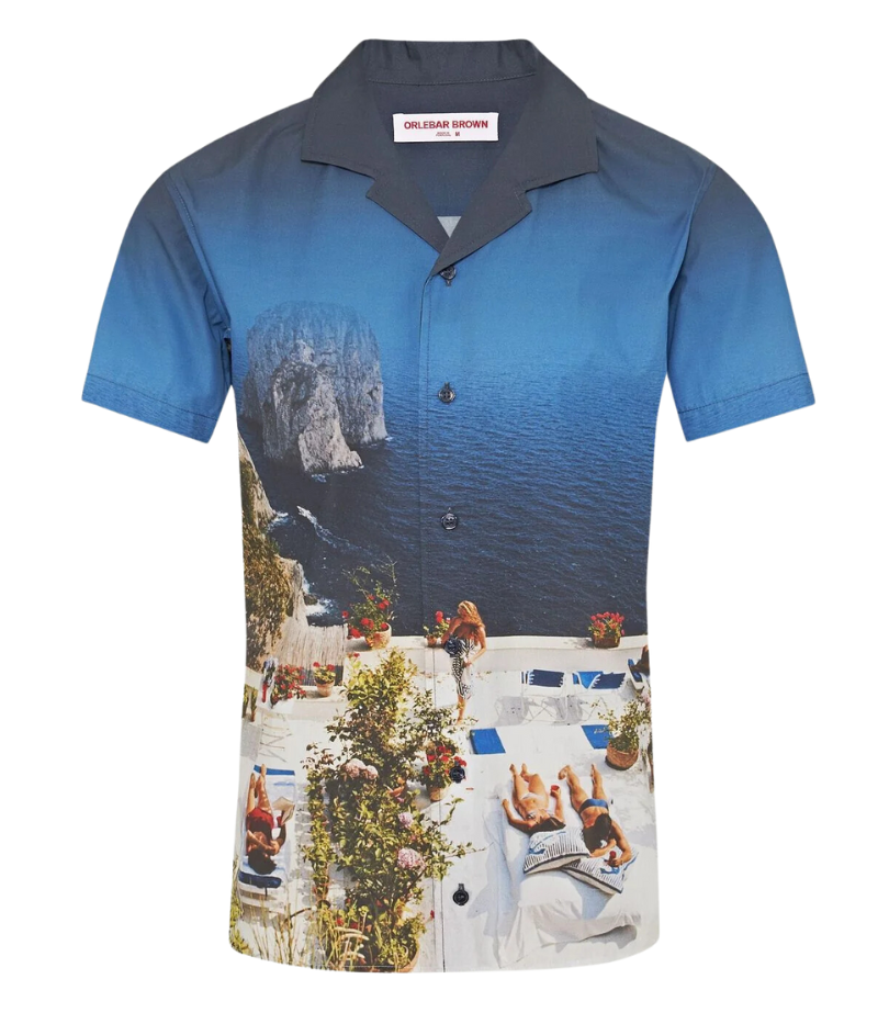 A statement short-sleeve shirt featuring an exclusive Slim Aarons photographic print of sunbathers at Villa Il Canille, a classic fit, Capri collar, and imitation mother-of-pearl buttons.