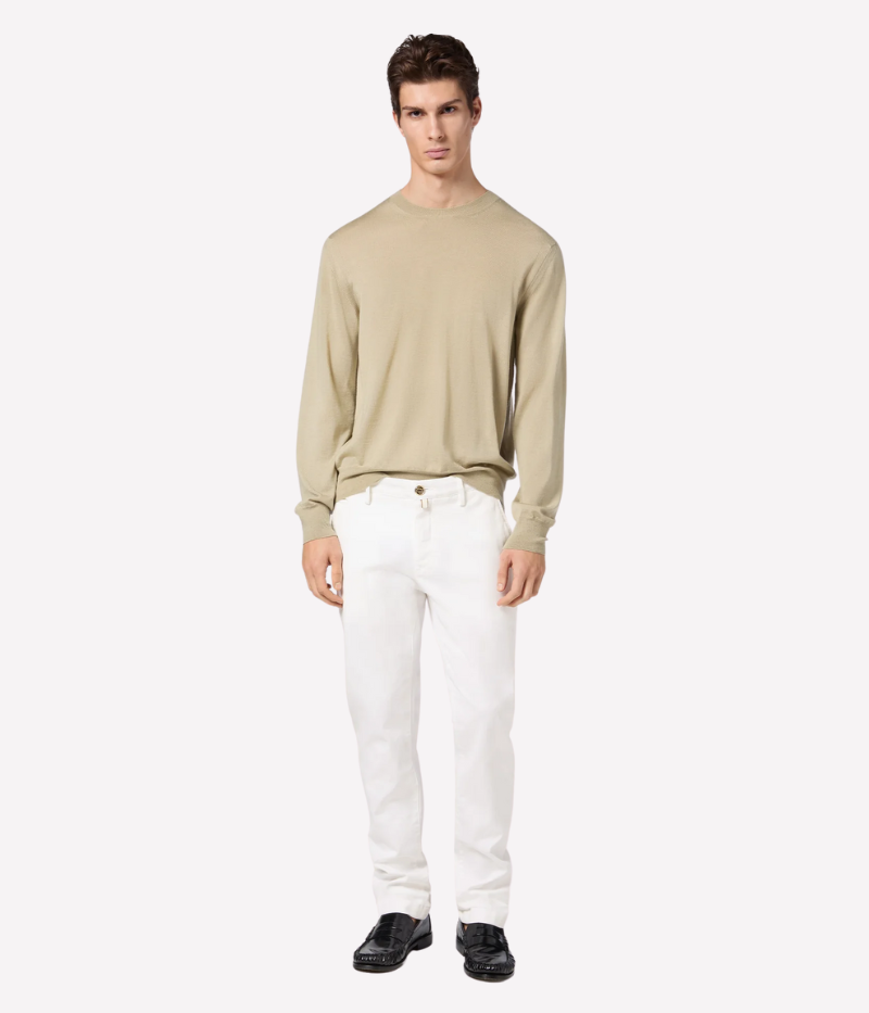 White slim-fit chino pants with a low waist, made from soft stretch cotton with an enzyme-washed, optical bleached finish. Features a white suede back patch with a gunmetal-finish logo and a gold-tone button. Made in Italy.