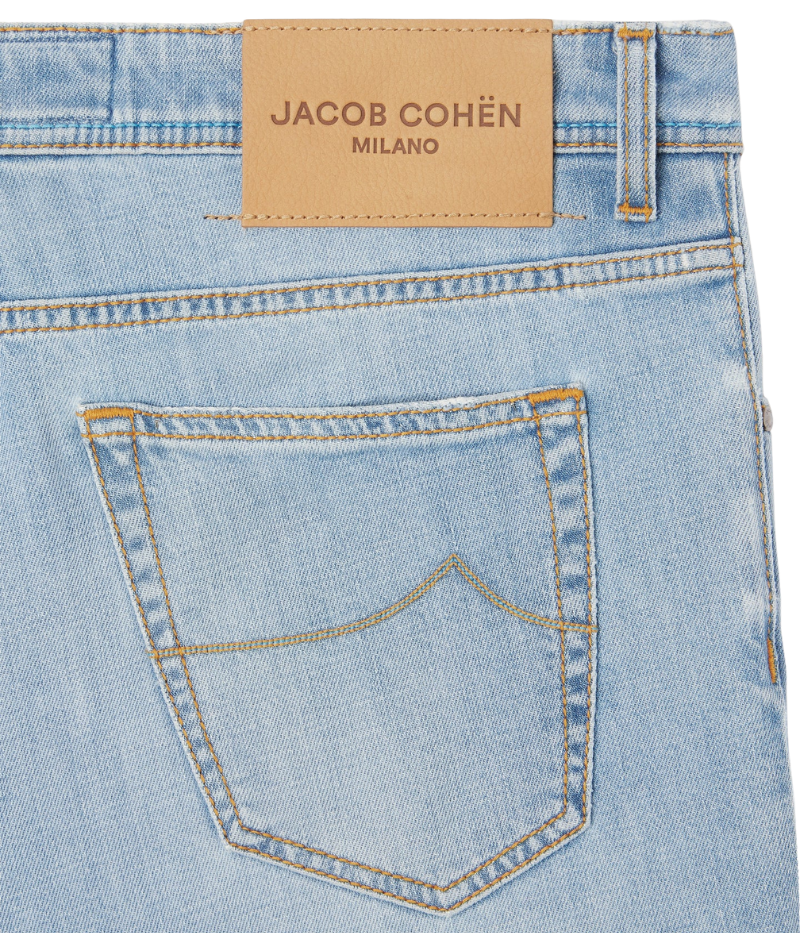 Light blue cropped carrot-leg jeans with a slim fit and low crotch. Made from soft, bleach-washed comfort denim with whiskering and distressed details. Features a beige nubuck back patch and vintage silver-tone button. Made in Italy.