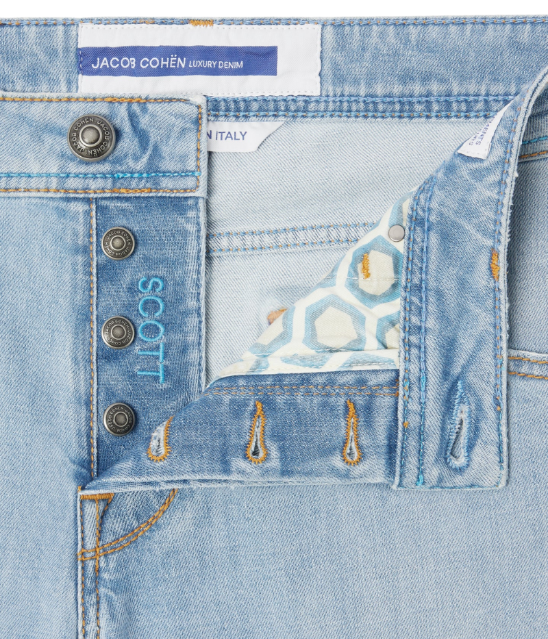 Light blue cropped carrot-leg jeans with a slim fit and low crotch. Made from soft, bleach-washed comfort denim with whiskering and distressed details. Features a beige nubuck back patch and vintage silver-tone button. Made in Italy.