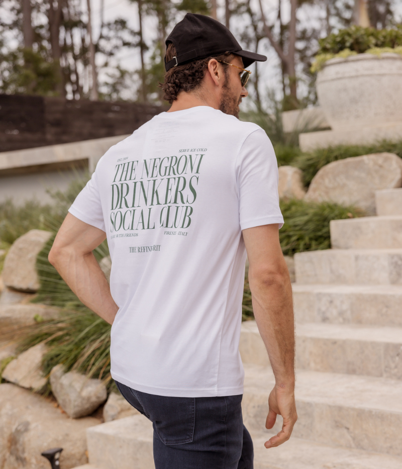 White graphic tee featuring "Negroni Drinkers Social Club" design, made from 100% organic cotton for a soft, durable feel and a classic fit.