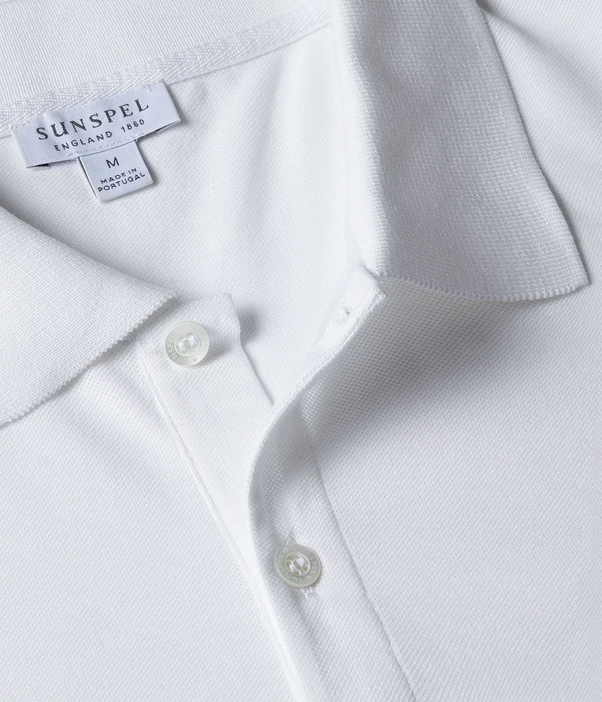 White piqué polo shirt for men made from premium Supima cotton. Ribbed collar, side vents, and branded shell buttons for a clean, stylish look.