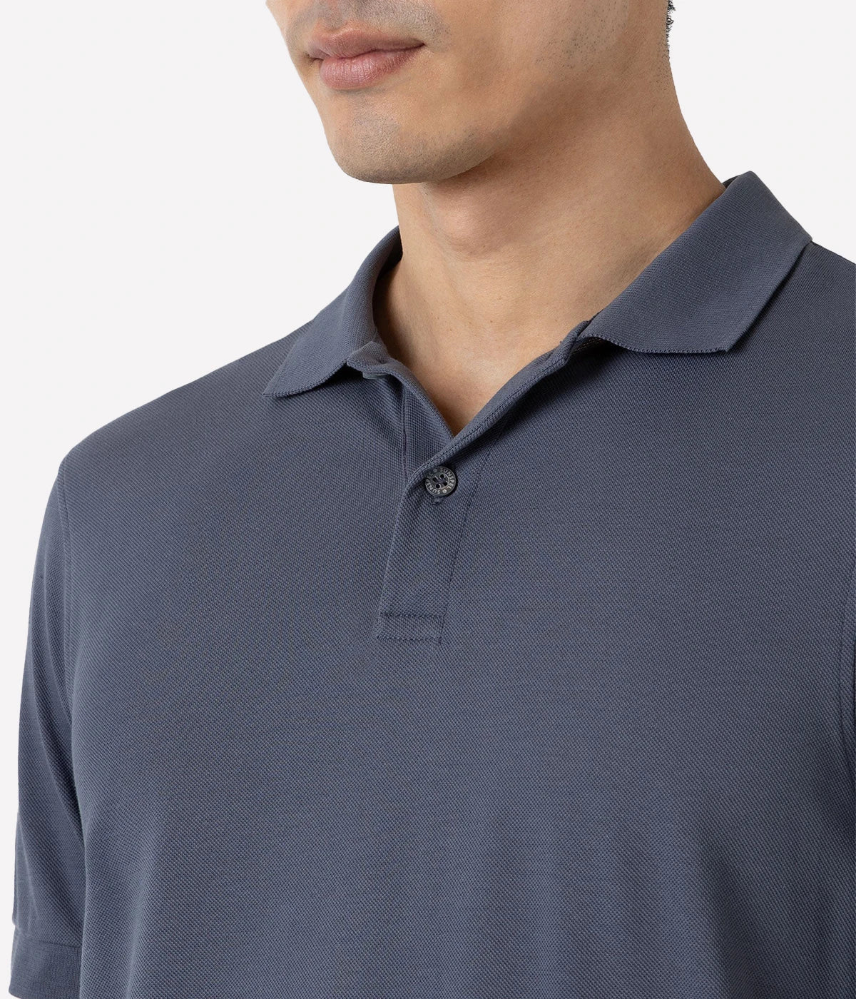 Slate blue piqué polo shirt for men made from Supima cotton. Features ribbed collar, side vents, and branded shell buttons for a polished look.