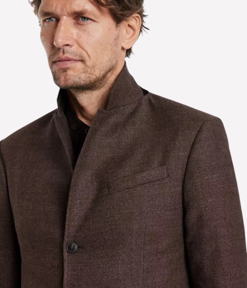 The Rind Jacket in Old Bark blends heritage craftsmanship with modern design, crafted from luxurious Italian goat suede with a rich, earthy tone and distinctive slubbed chine texture. Featuring notch lapels, flap pockets, and a hidden suede accent beneath the collar, this jacket offers timeless sophistication with a contemporary edge, making it a versatile statement piece for any refined wardrobe.