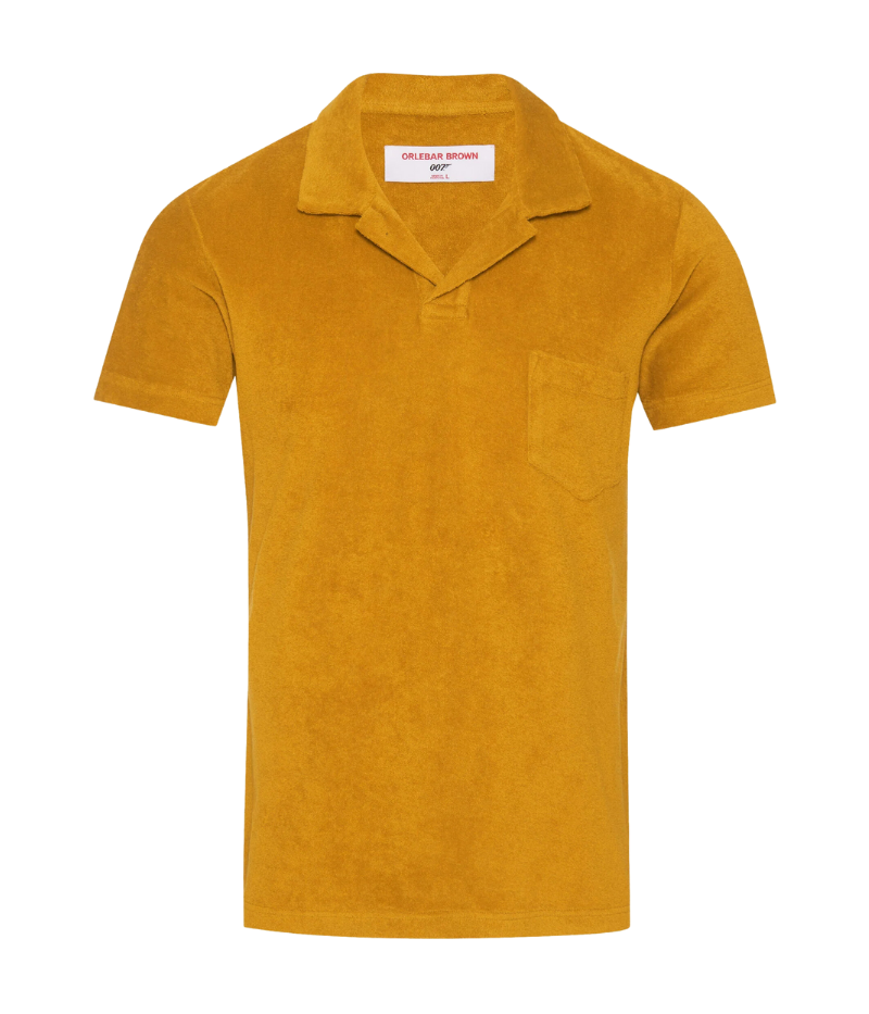 Orlebar Brown Terry Towelling Polo in Gold, inspired by The Man with the Golden Gun. Crafted from soft terry towelling cotton, this tailored-fit polo features a buttonless placket and straight-cut silhouette for effortless elegance. A nod to timeless Bond style, it pairs perfectly with tailored shorts or for a breezy evening look.