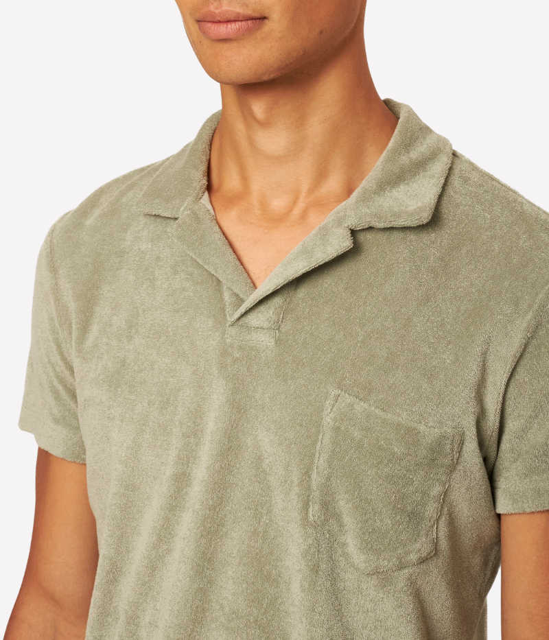 Orlebar Brown Terry Towelling Polo in Penny Green, inspired by The Man with the Golden Gun. Made from soft terry towelling cotton, this vintage-style polo features a tailored fit, straight-cut silhouette, and a buttonless placket for a refined, effortless look. Perfect for both casual and dressed-up occasions, this piece offers the ideal balance of sophistication and comfort.